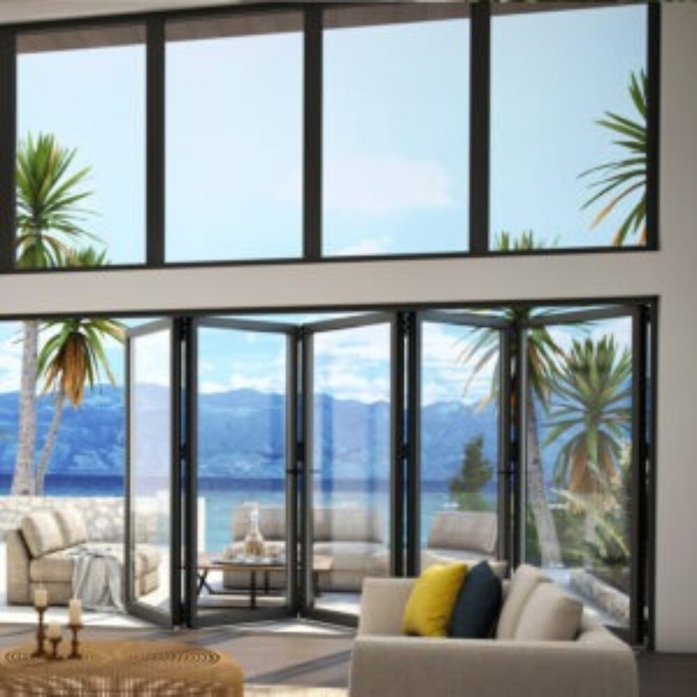 Helles Wohnzimmer mit großen Glas-Faltwänden, die sich zur Terrasse mit Meerblick und Palmen öffnen.